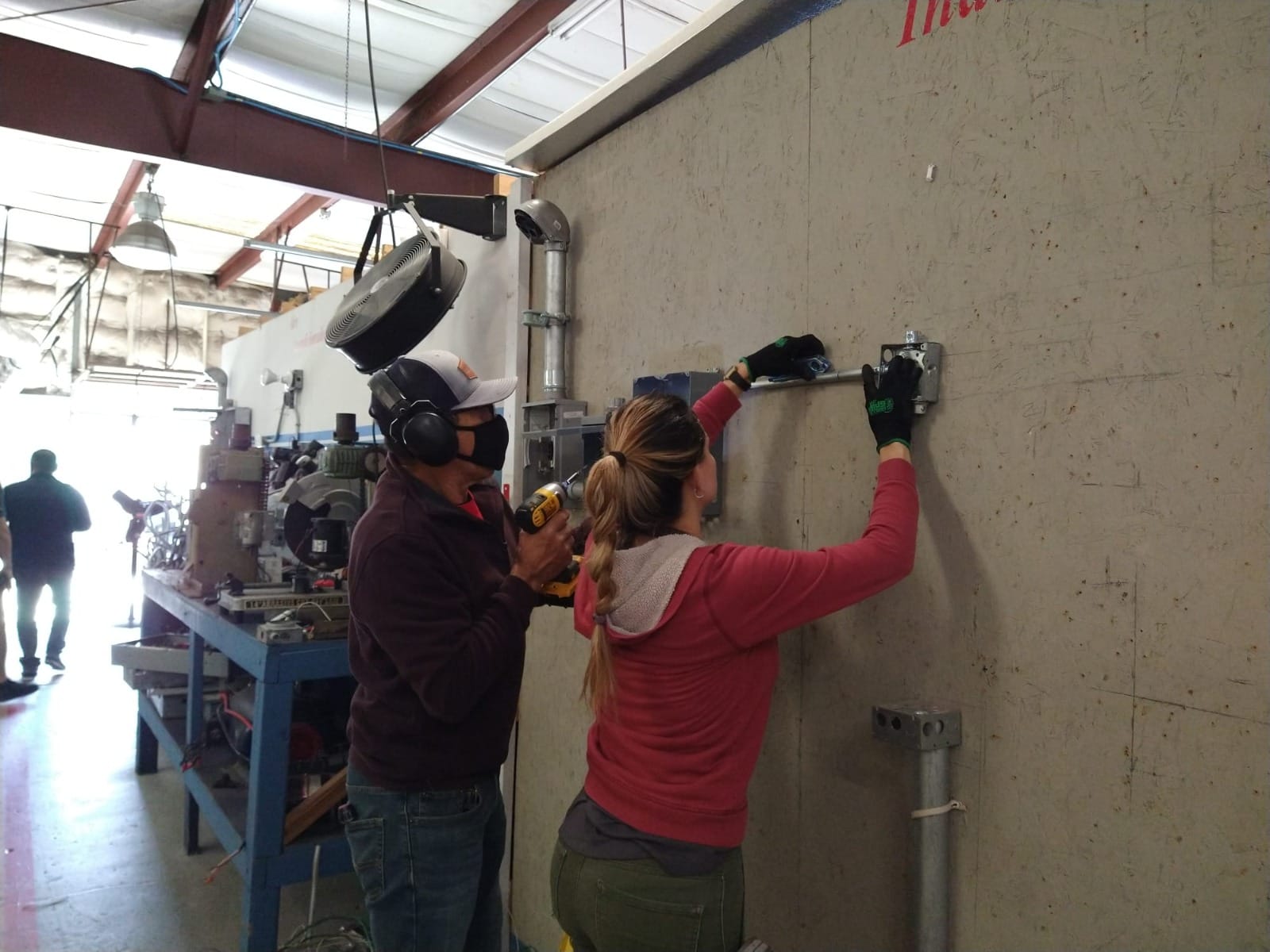 Grupo de estudiantes revisando equipo HVAC junto a instructor en taller del ITA.