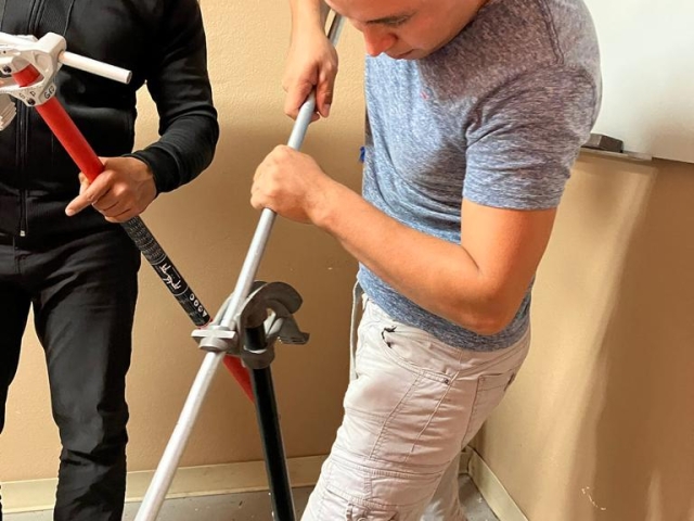 Estudiante del curso de Electricidad de ITA realizando práctica de instalación eléctrica con tuberías.