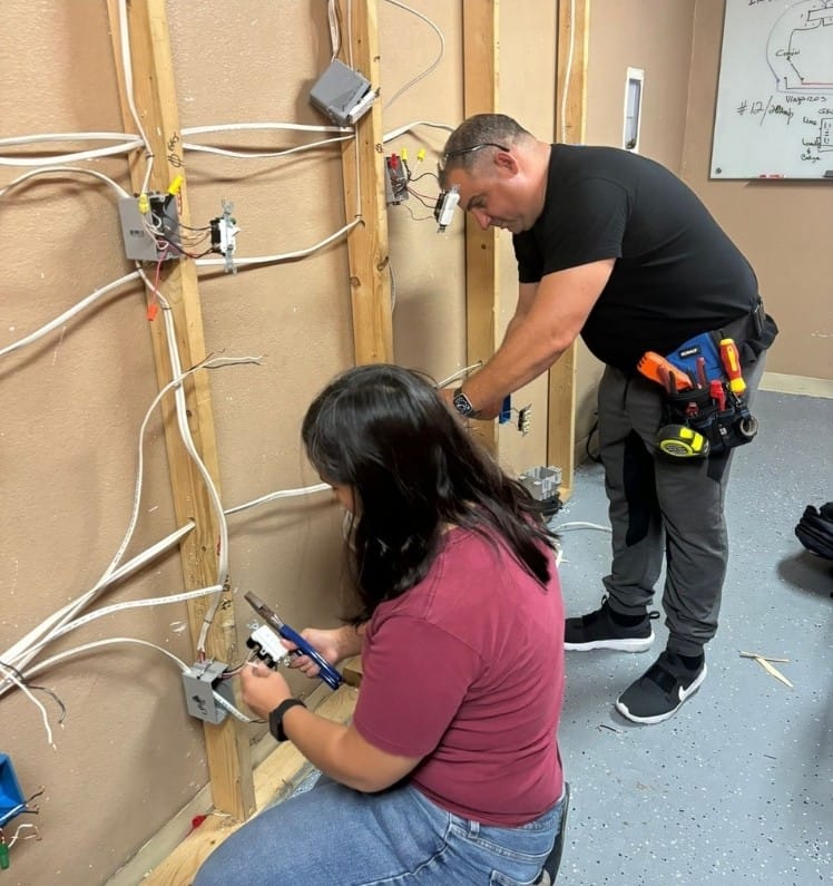 Estudiantes del Instituto Tecnológico Americano realizando prácticas del curso de aire acondicionado con un equipo de climatización.