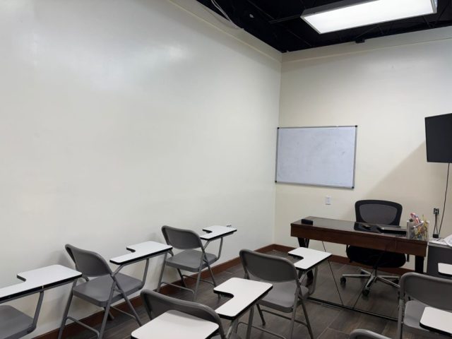 Aulas de formación del Instituto Tecnológico Americano Aula de clases del Instituto Tecnológico Americano con escritorios y espacio para enseñanza teórica.