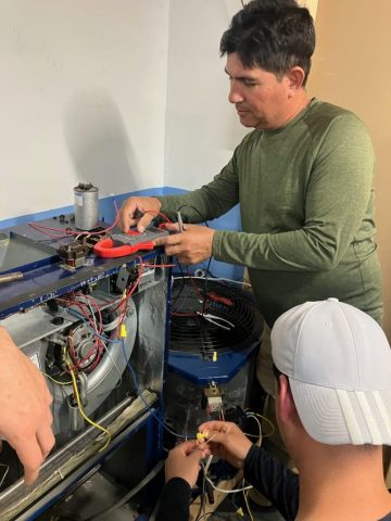 Práctica de diagnóstico eléctrico en aire acondicionado – ITA Estudiantes realizando diagnóstico eléctrico en equipo de aire acondicionado durante clase práctica en ITA.