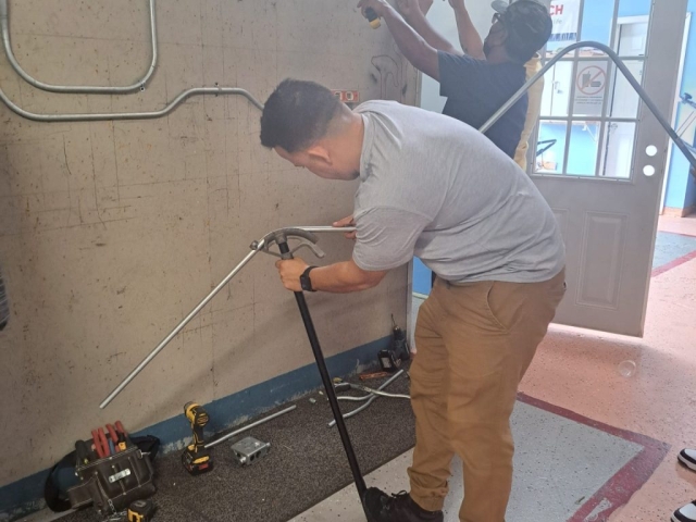 Estudiantes del curso de Electricidad del ITA Columbus practicando instalación eléctrica con herramientas profesionales.